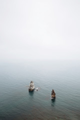 Rocks stick out of the sea. Seascape with fog - 352600628