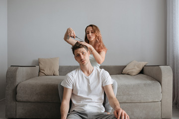 Indoor haircut during the coronovirus pandemic.
Wife helps husband with haircut at home - 352601034