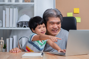 Asian father is work at the home with a daughter and studying online learning from school together. New lifestyle normal during a quarantine. Concept of stay home, freelance and fatherhood concept