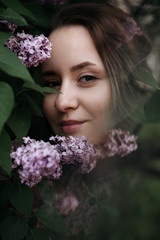 Soft focus portrait of young girl near lilac - 352601293