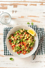 Vegan salad with couscous , vegetables and olive oil on white