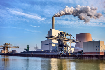 Power plant with chimneys and smoke at the riverbank