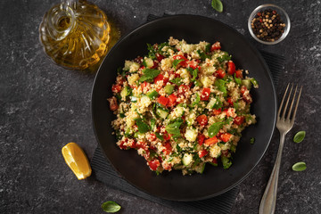 A plate with vegan refreshing couscous salad on back background