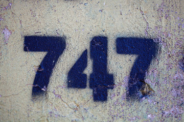 number 747 on a stone  wall