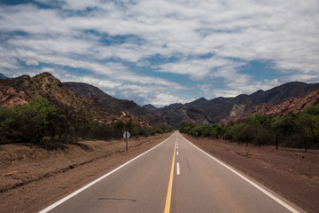carretera o ruta por entre medio de las montañas en la naturaleza del norte argentino argentina jujuy con nuebes en el cielo