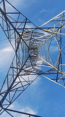 Low Angle View Of Electricity Pylon Against Blue Sky