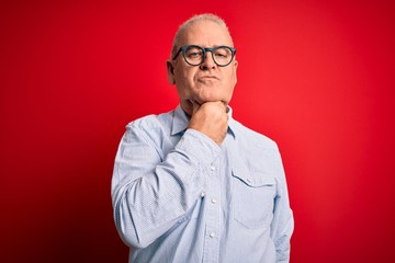 Obraz premium Middle age handsome hoary man wearing casual striped shirt and glasses over red background Touching painful neck, sore throat for flu, clod and infection