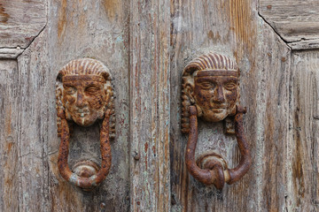 rusty door knocker on a weathered door