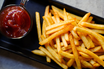 Close-up french fries with ketchup on black plate, close-up of french fries 