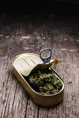 cannabis in a tin can. on old wooden background. rustic