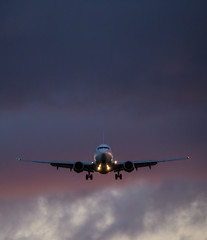 Commercial airplane jetliner flying above dramatic clouds in beautiful light. Travel concept.
