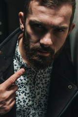 “Don’t mess with me”. Aggressive and rugged bearded man looking in camera with gesture of his...