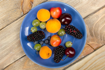Various summer Fresh berries in a bowl on rustic wooden table. .Antioxidants, detox diet, organic fruits. Top view