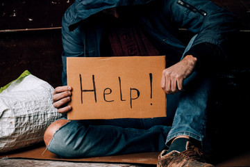 A homeless person holds a sign , asks for work, and seeks help. The concept of poverty and...