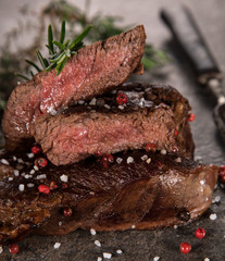 Grilled tasty beef steak on black stone table., close-up.