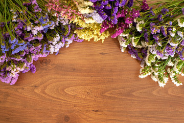 Background made with natural  brown wood and composition of statice flowers