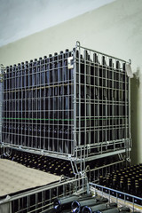 Stacked wine bottles in metal grids before to be labeled - pattern background