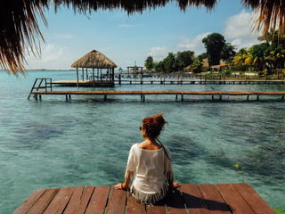  Chica de espaldas mirando al lago en Laguna Bacalar, Quintana Roo, Méjico. Agua turquesa. Vacaciones. © Alex