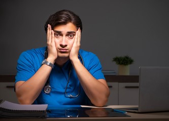 Young handsome doctor working night shift in hospital