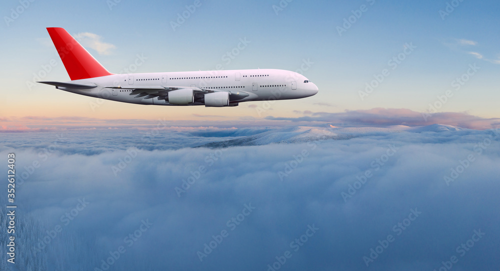 Wall mural commercial airplane jetliner flying above dramatic clouds in beautiful light. travel concept.