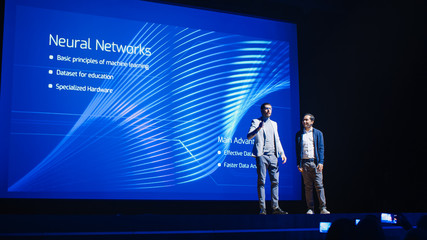 Startup CEO and Chief Developer Stand on Stage and Present New Product. Speakers Lead Lecture on Business, Science, Technology, Entrepreneurship, Health, Ecology, Leadership and all Things Digital