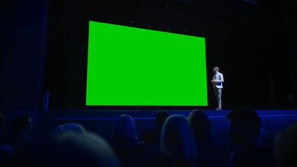 Keynote Speaker Announces New Product to the Audience, Behind Him Movie Theater with Green Screen, Mock-up, Chroma Key. Business Conference Live Event or Device Reveal