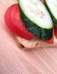 sandwich with bread with tomatoes and cucumbers on a wooden table.