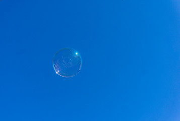 Single soap bubble against blue sky