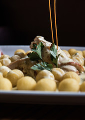 pasta casera, &ntilde;oquis con salsa y decoracion con fondo oscuro