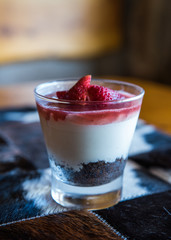 postre de fresas nata batida y chocolate en vaso de cristal con fondo desenfocado