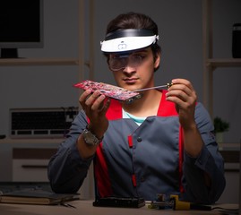 Young handsome repairman repairing computer