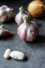 Garlic, onions and beans on a dark background. Still life with onions of garlic and onions. Top view with place for text.