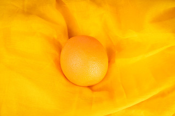 Orange fruit on orange cloth view from the top.