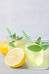 Lemon lemonade with herb on grey background.