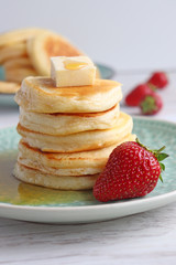 Pancakes mit Ahornsirup, Butter und Erdbeeren