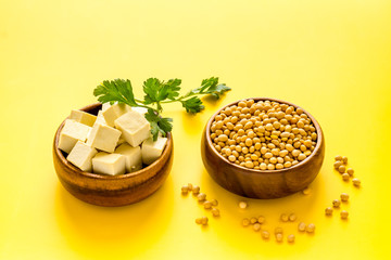 Tofu cubes with soybeans on yellow kitchen table