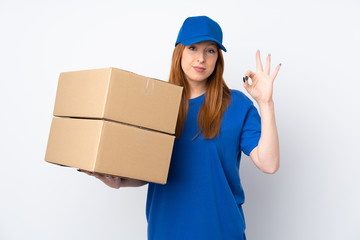 Young delivery woman over isolated white background showing an ok sign with fingers