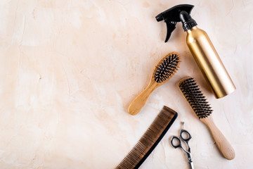 Hairdresser set in beauty salon. Combs, scissors, spray on beige desk top-down copy space