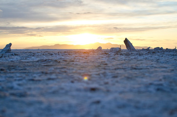 The glowing sunlight on the salty shores of the great salt lake in the utah desert landscape. 