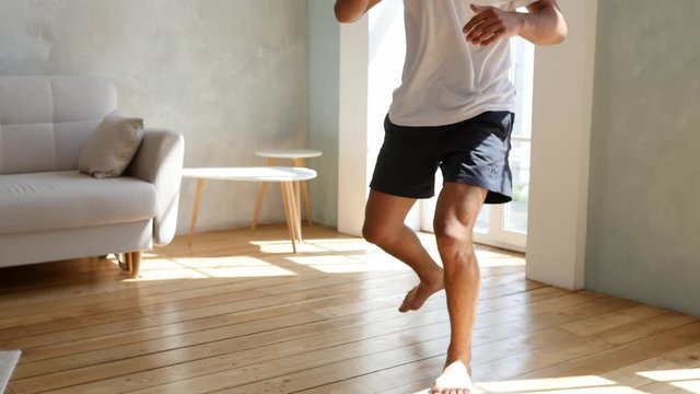 Kickboxer training at home. Athlete boxing to the camera. Medium shot with camera shake when a boxer hits. Self defense, sambo wrestler. The muscular legs of a black man.