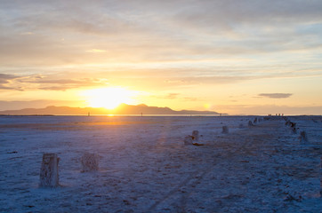 The golden sunset over the salt lake ruins and the wide open salt flat landscape in the evening light. 
