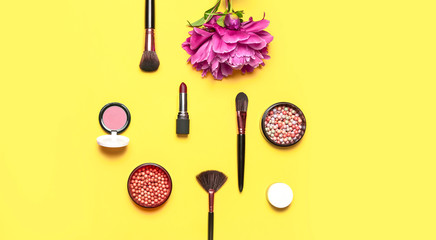 Professional makeup brushes, powder, eyeshadow, blush, lipstick cream on yellow background flat lay top view copy space. Beauty product women's accessory fashion. Different brushes Cosmetic makeup Set