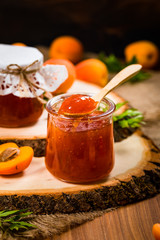 Apricot Jam with Fresh Apricot on Wooden Background. Selective focus.