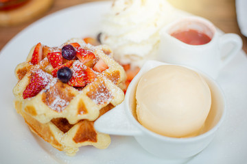 Belgian waffles with vanilla ice cream and isolated strawberries