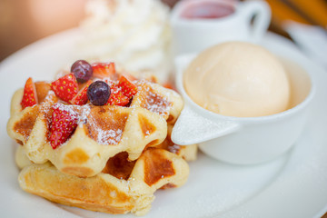 Belgian waffles with vanilla ice cream and isolated strawberries