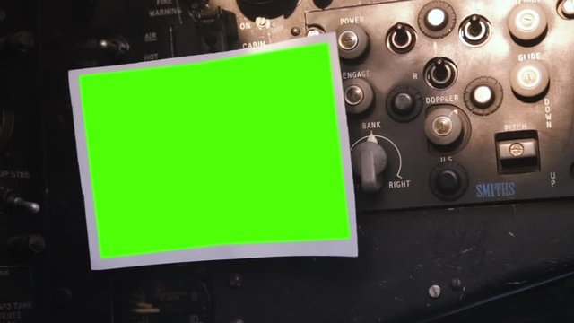 An Empty Photo with Chroma Background inside the Cockpit of an Old Bomber. You can replace green screen with the footage or picture you want. You can do it with “Keying” effect in After Effects.
