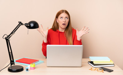 Young student woman in a workplace with a laptop frustrated by a bad situation