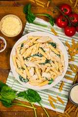 Chicken Alfredo with Spinach on Wooden Background. Selective focus.