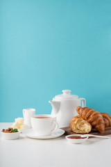 Fresh delicious breakfast with hot tea and  croissants - obrazy, fototapety, plakaty