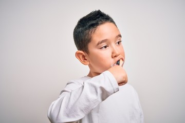 Young little kid boy brushing her teeth using tooth brush and oral paste, cleaning teeth and tongue as healthy health care morning routine. Learning dental education